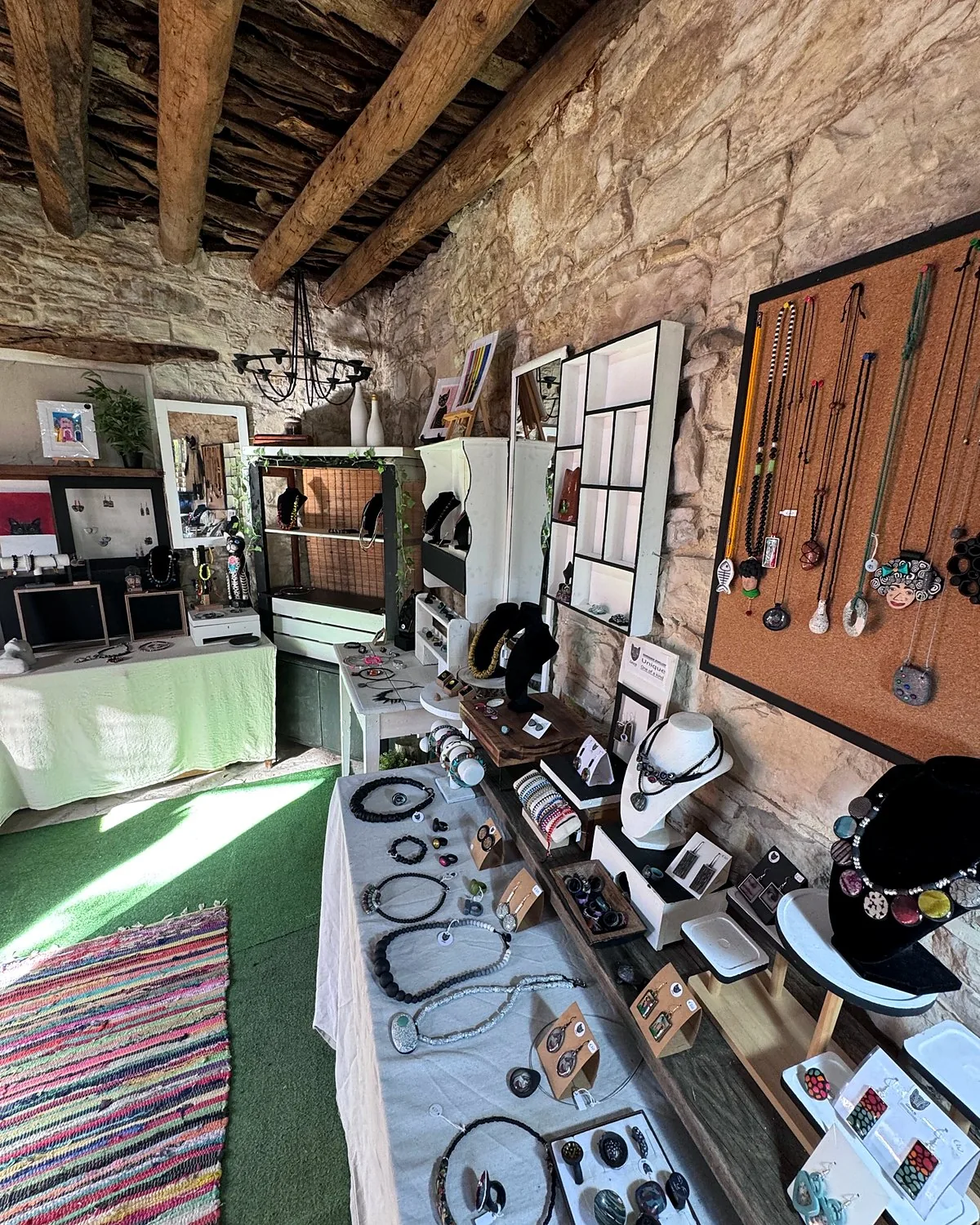 Lania village, Cyprus: we walked into every open door Handmade jewellery on tables and walls inside a stone studio with wooden beams in Lania, Cyprus