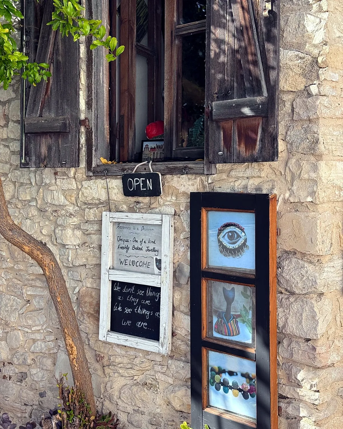 Lania village, Cyprus: we walked into every open door Stone house in Lania with wooden shutters, a hand-lettered OPEN sign and framed art by the door