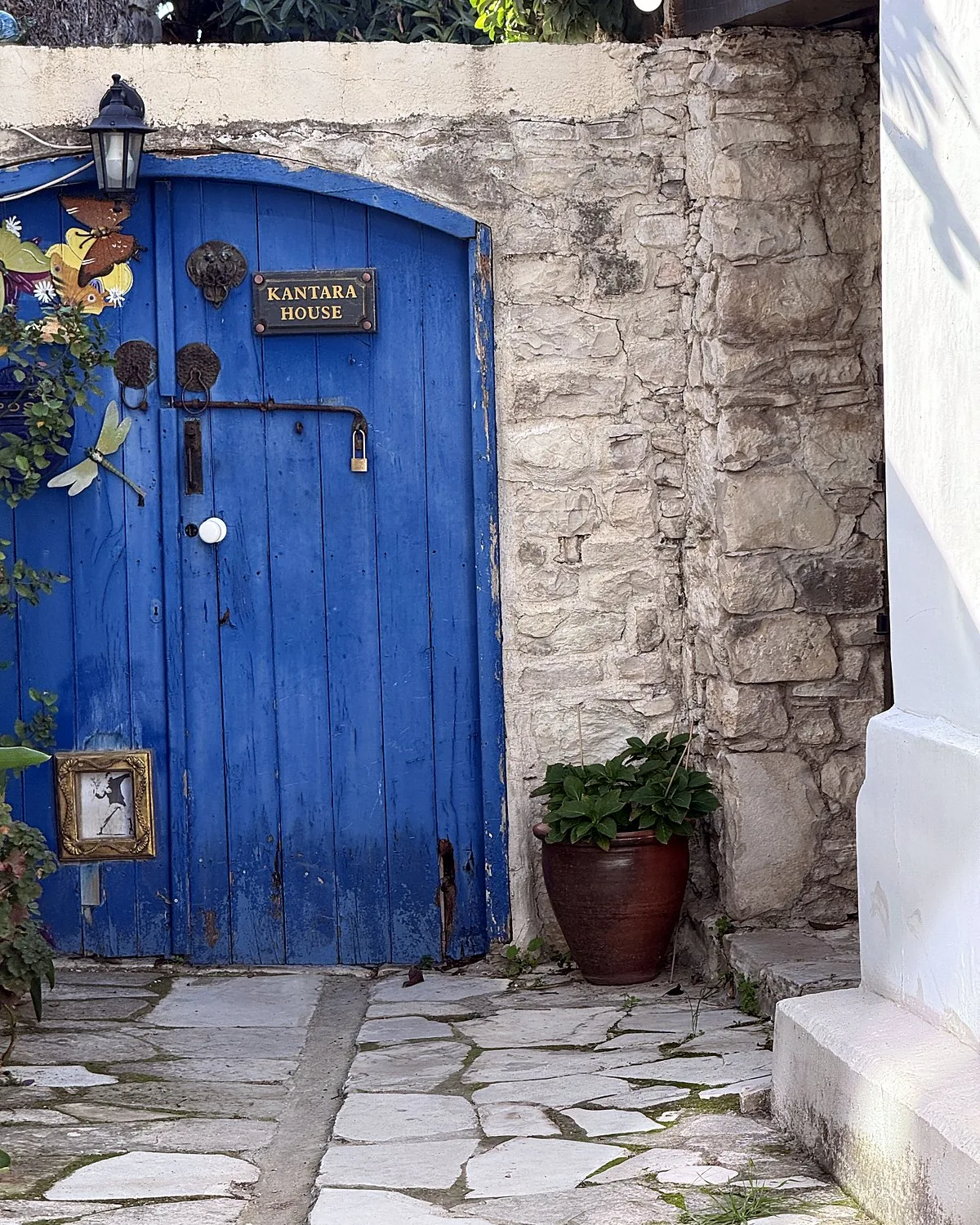 Lania village, Cyprus: we walked into every open door Blue wooden door with a Kantara House sign beside a stone wall in Lania, Cyprus