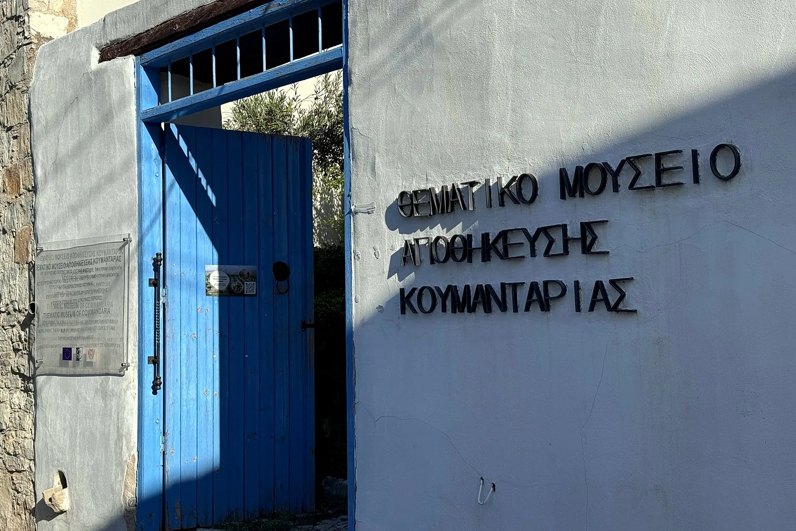 Lania village, Cyprus: we walked into every open door Blue door and Greek lettering reading Thematic Museum of Commandaria Storage in Lania, Cyprus