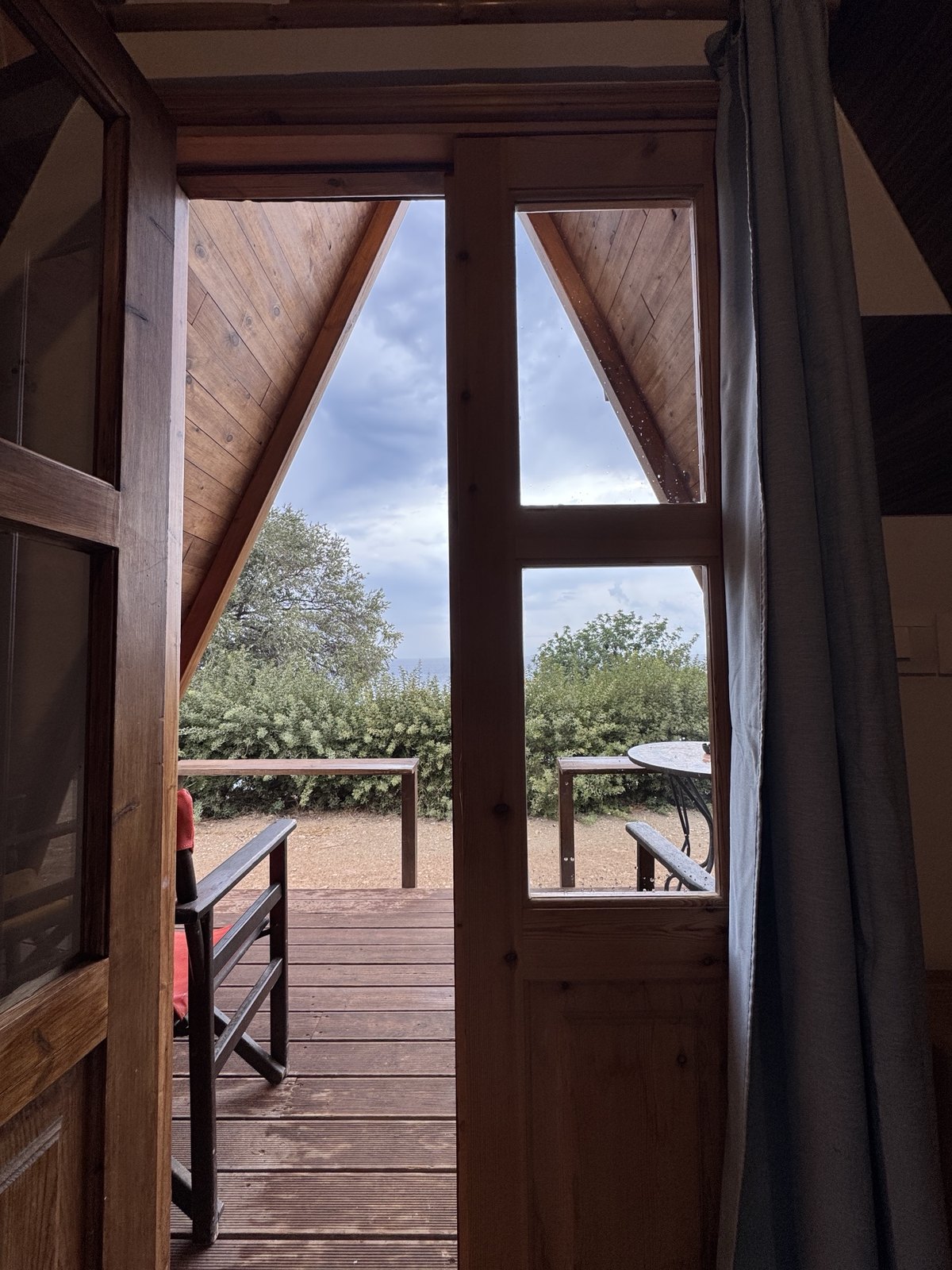 View from an A-frame wooden bungalow onto the deck at the camp