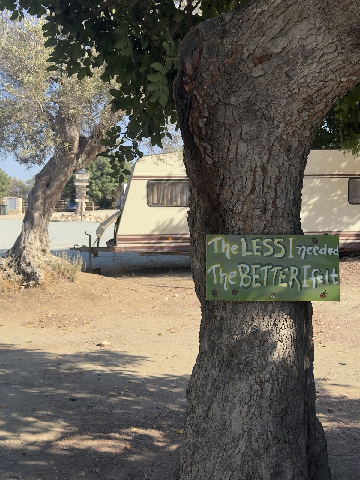 Hand-painted sign at the camp: The less I needed, the better I felt